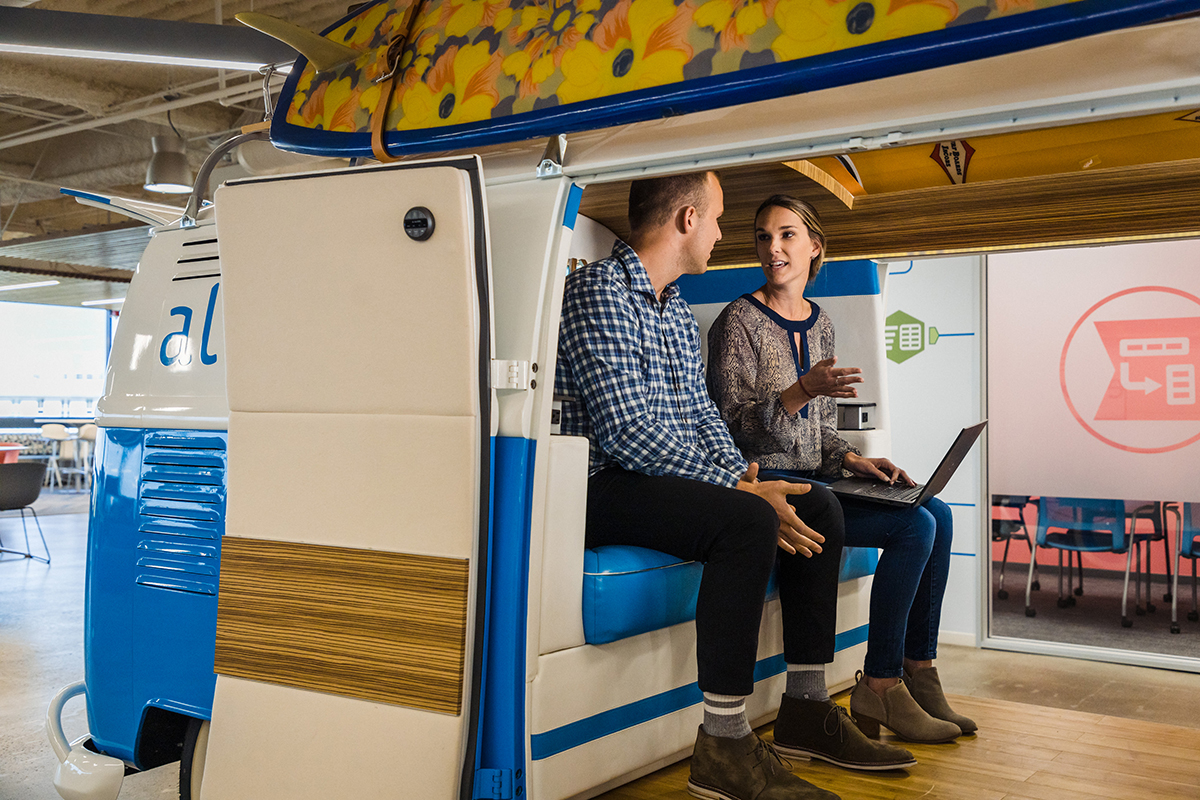Two Alteryx coworkers having a team huddle in a VW van in the office