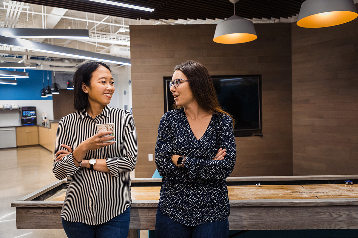 Two Alteryx team members chatting in the office