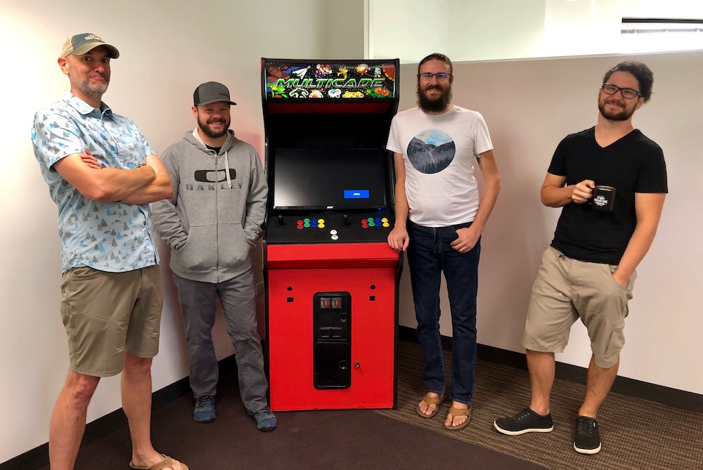 ArcherDX employees next to built arcade machine