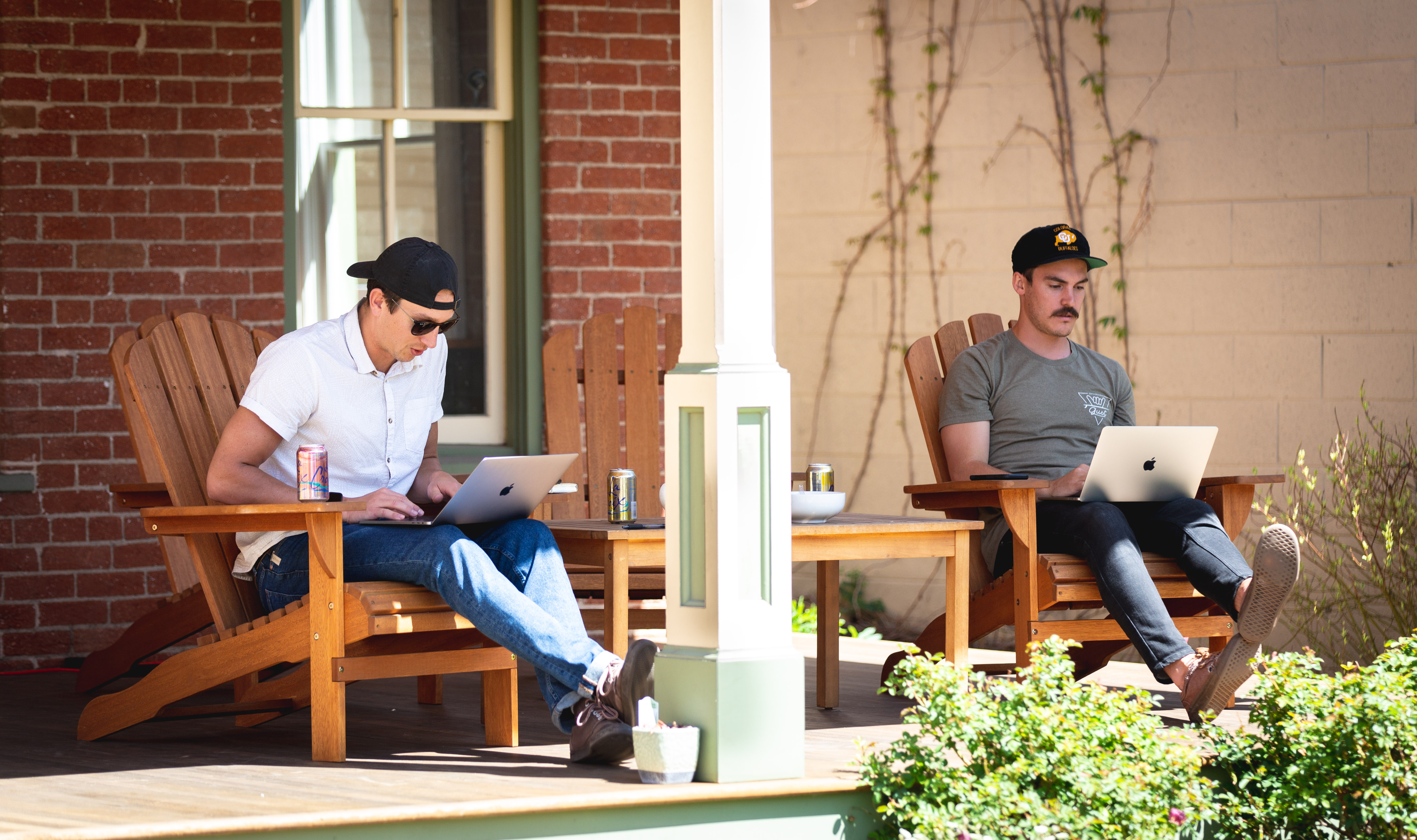 Two men sitting outside in chairs working