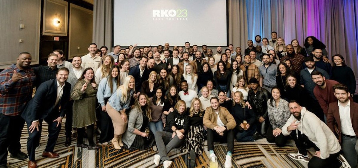 The Checkr team poses under a projection of RKO23 at their 2023 revenue kickoff