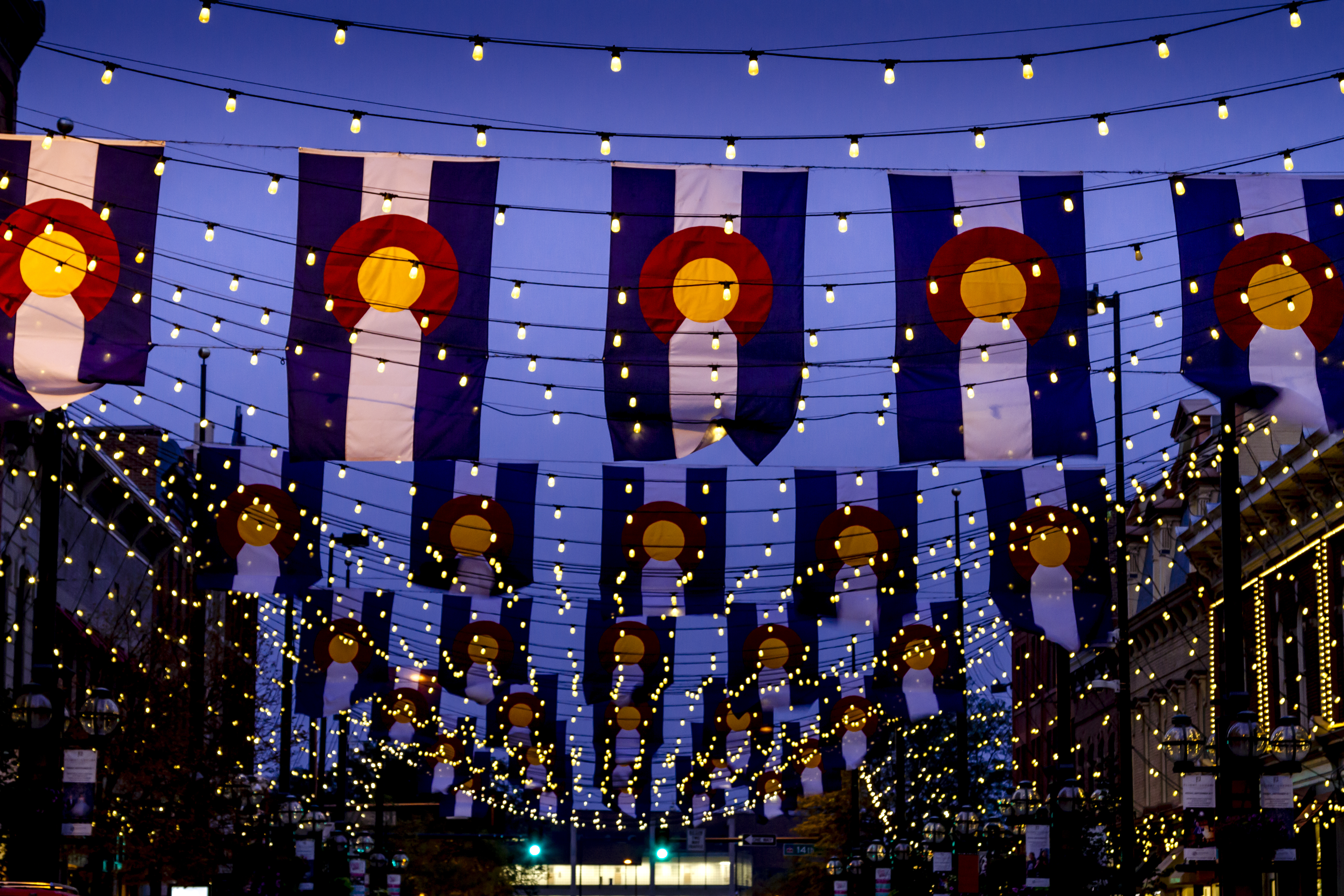 nighttime photo of colorado flags with string lights