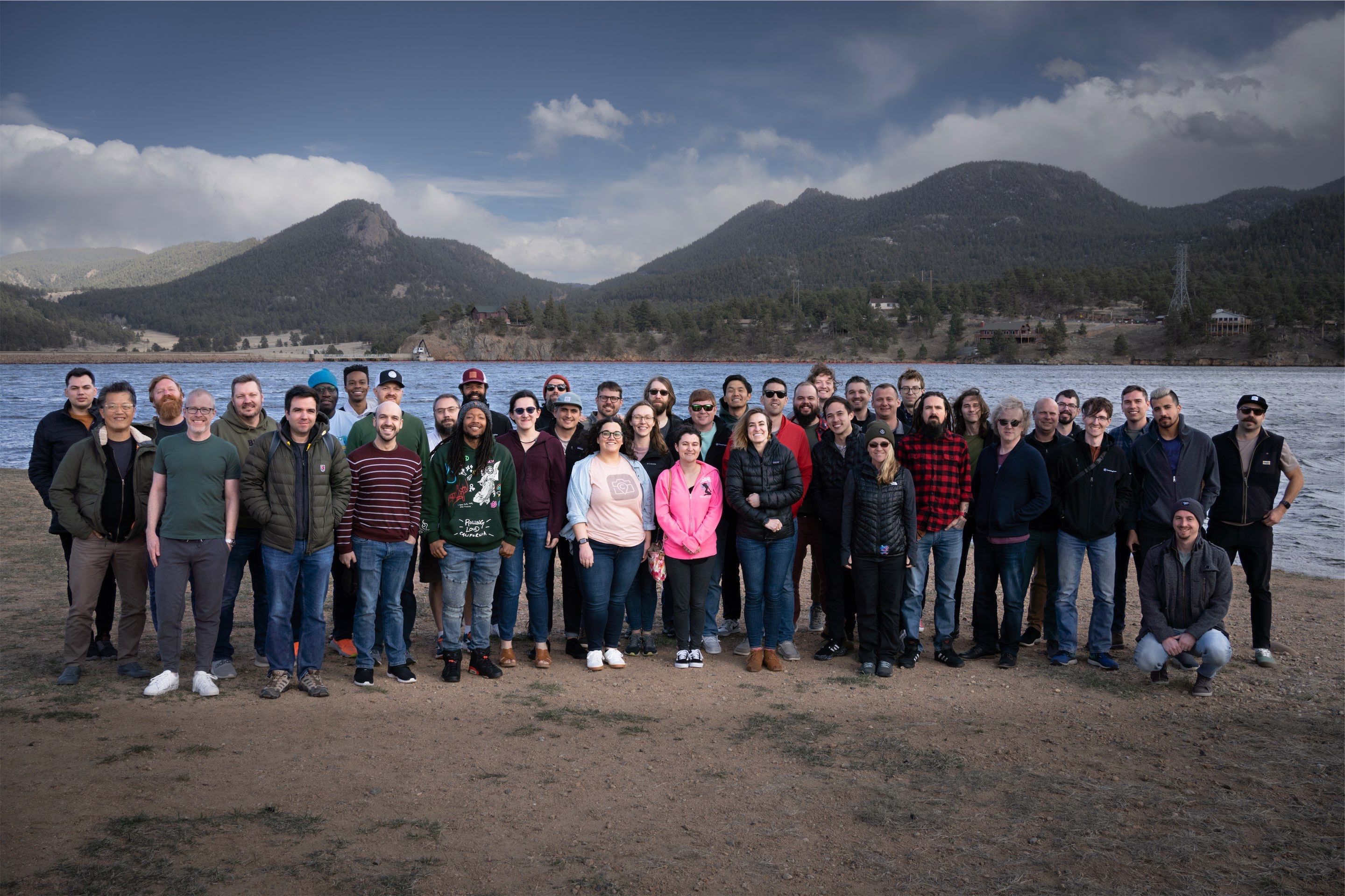Large group photo of CompanyCam team with lake and mountains in background.