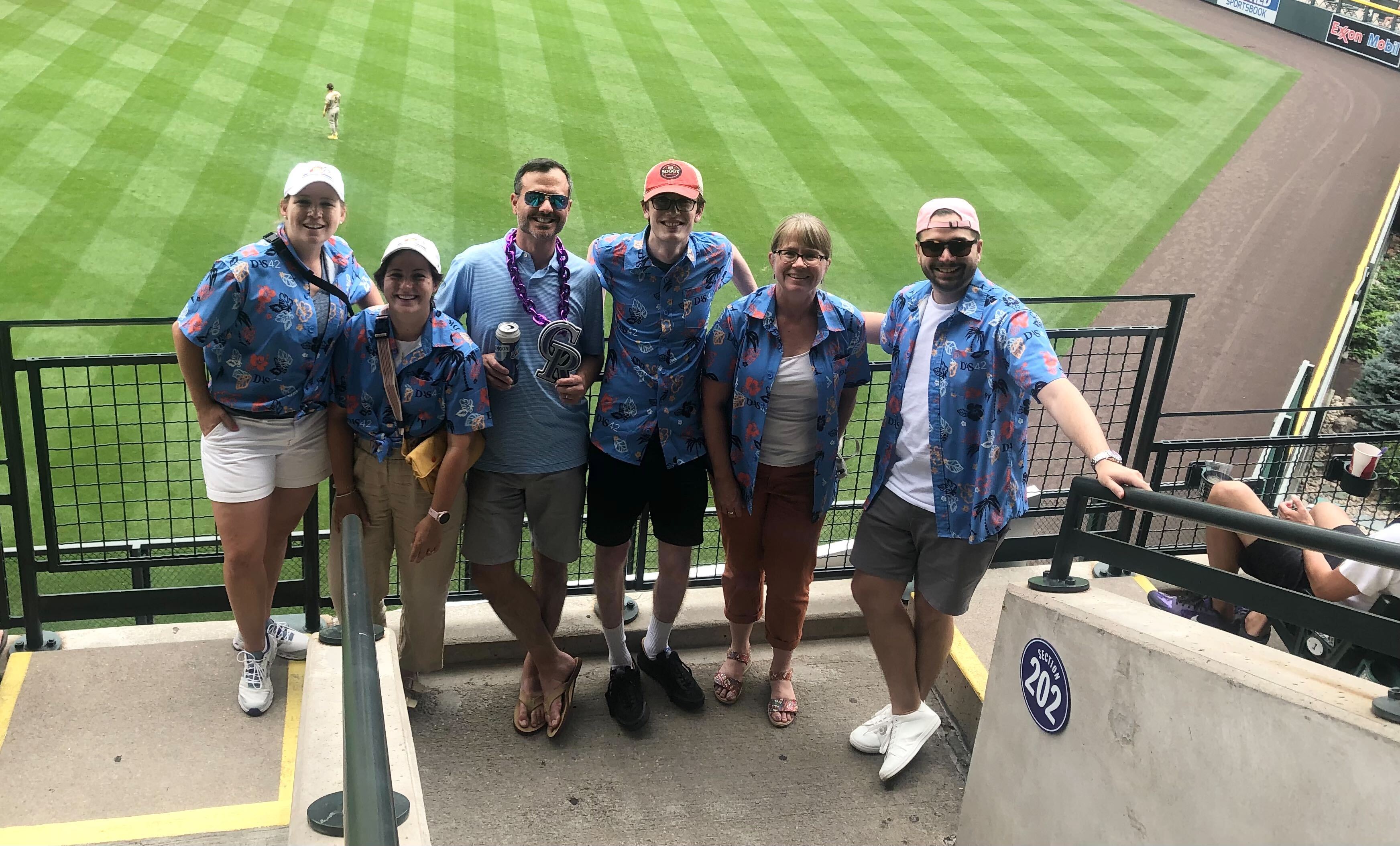 The DAS42 team attends a baseball game in matching Hawaiian shirts.