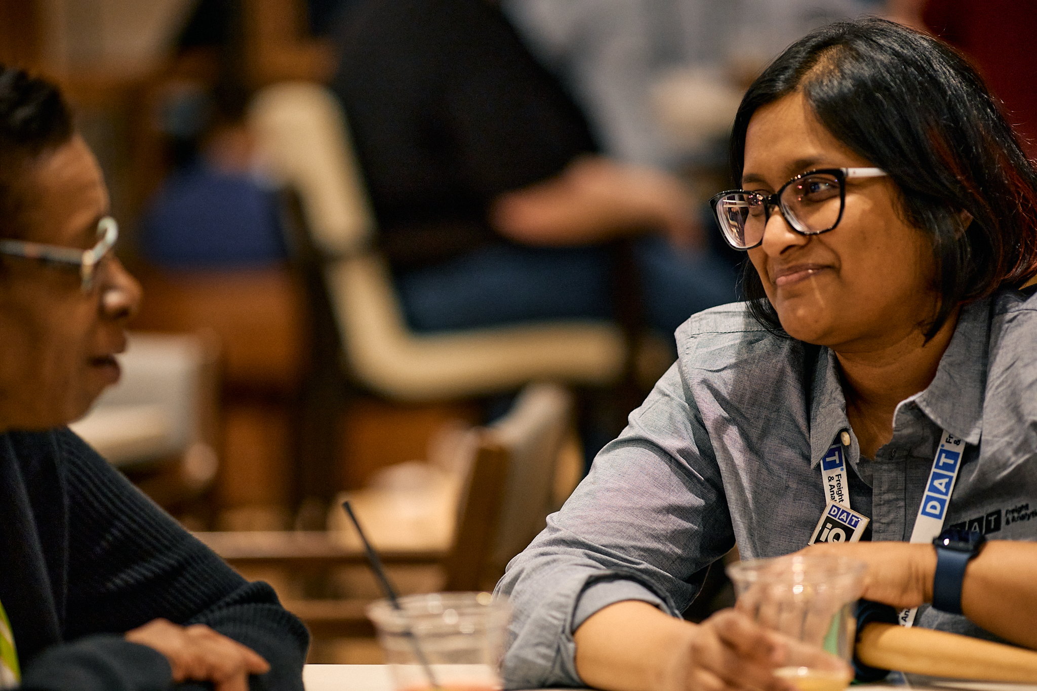 Candid photo of two DAT team members smiling and talking at a table.