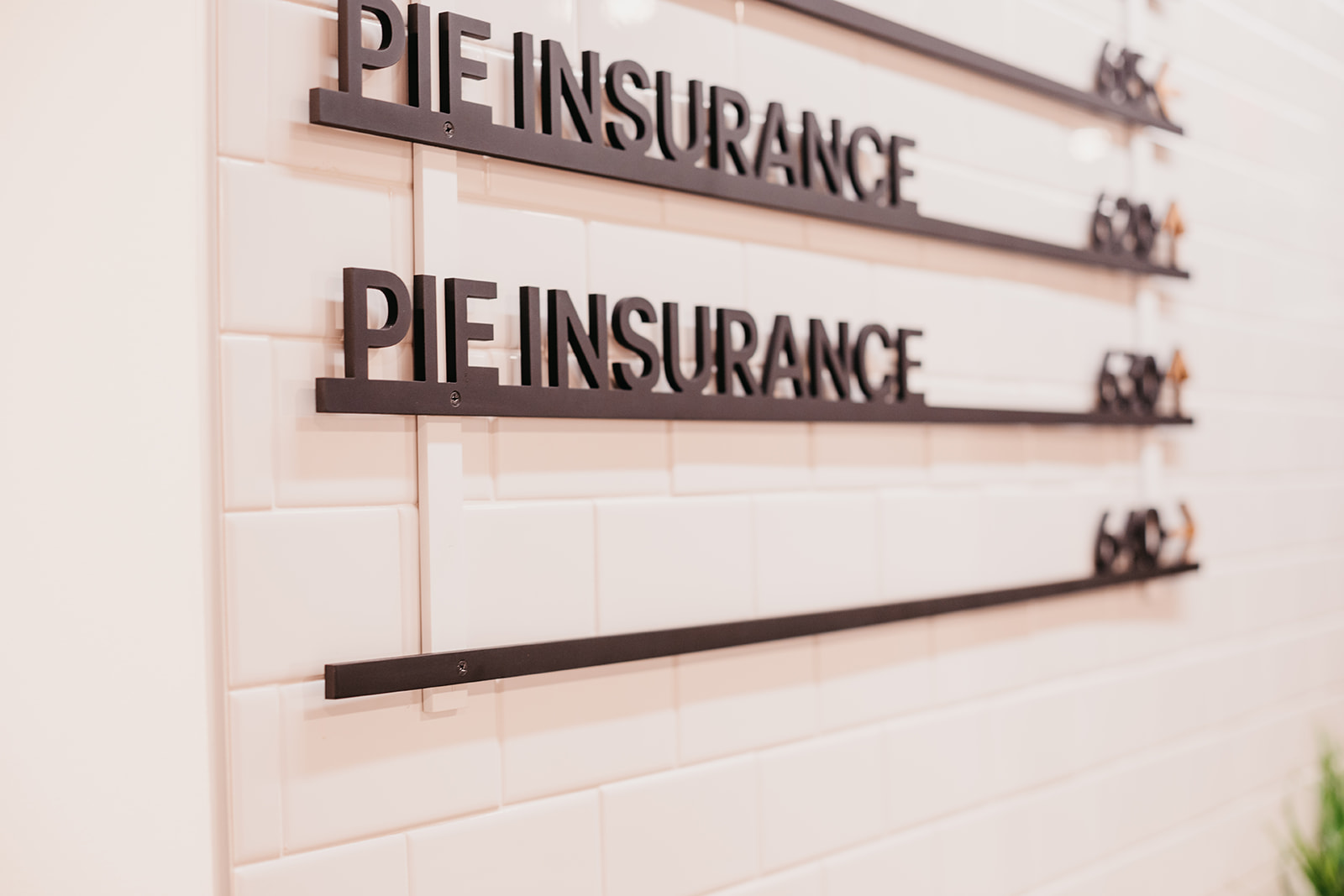 two stylized floor signs with underlines, both saying Pie Insurance