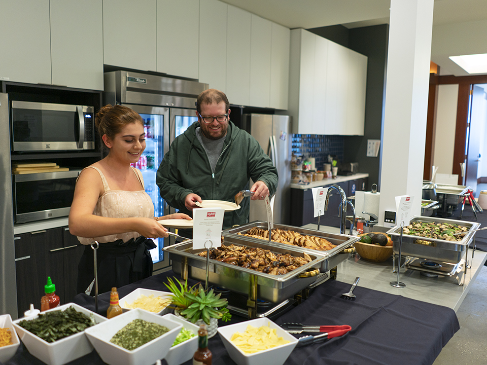DISQO employees helping themselves to a catered meal in the office kitchen.