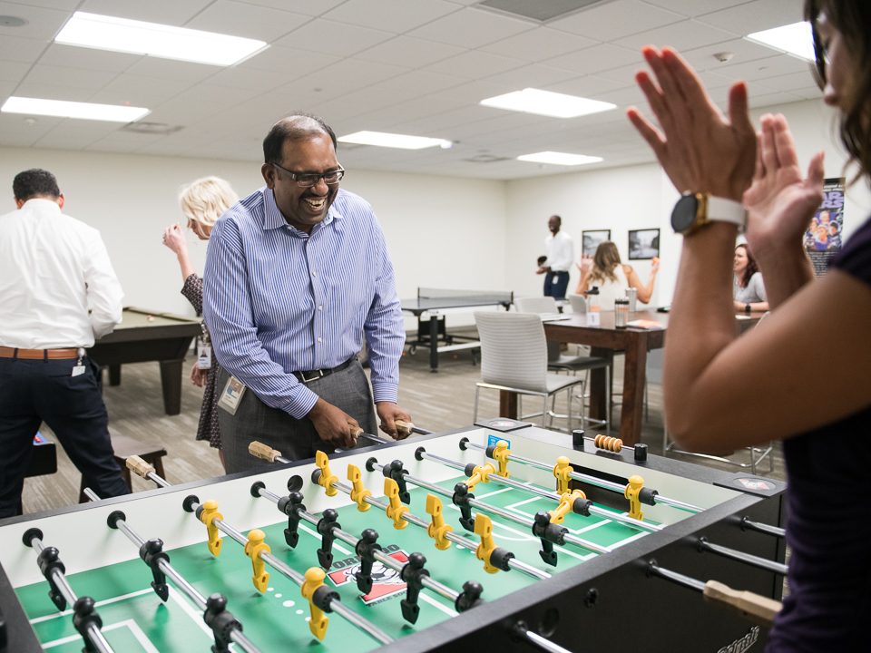 Josh Chandra plays foosball with a coworker
