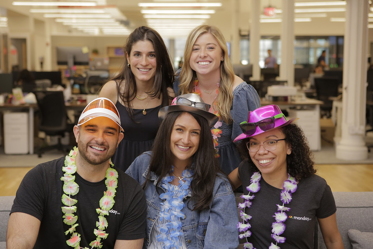 monday.com team members wearing hats and leis