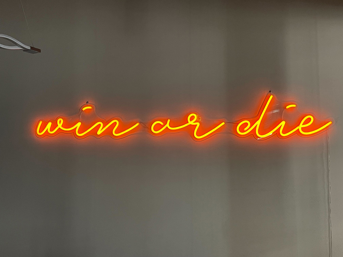 Neon sign that says win or die
