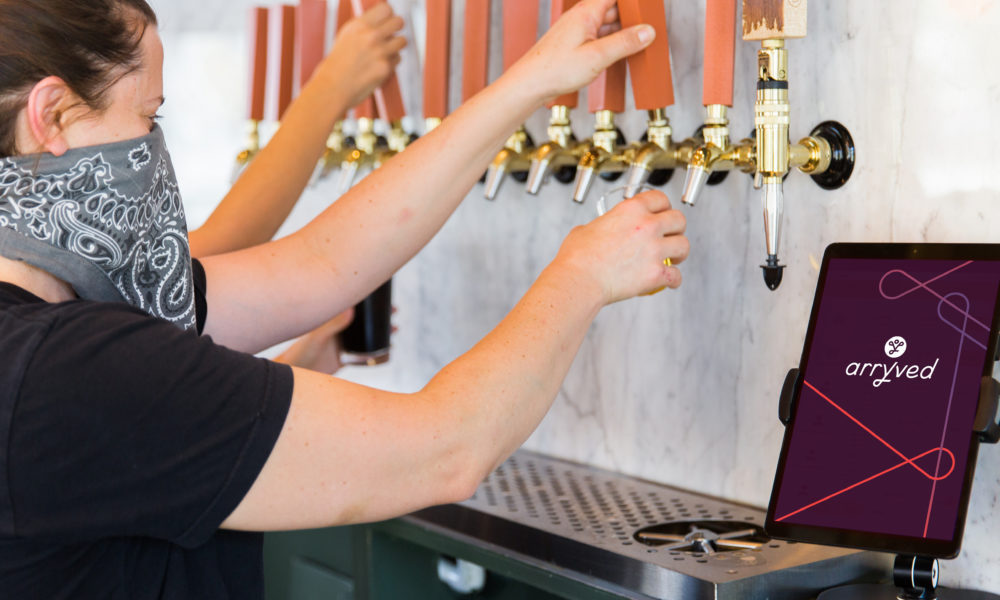 arryved tablet next to person pouring beer from draft.