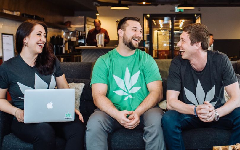 Three individuals sitting on the couch in Flowhub's office, wearing their logo on t-shirts.