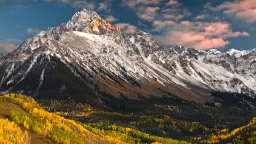 Image of Colorado's Rocky Mountains above green and yellow trees in autumn