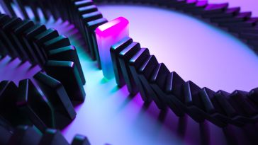 Concept photo of a line of black dominoes falling until they are stopped by a glowing purple domino. 