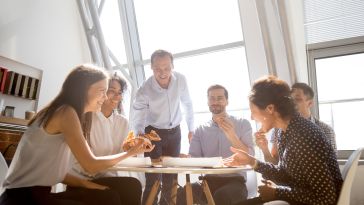 Employees laughing during a meeting.
