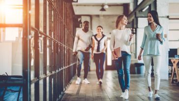 Image of two pairs of coworkers walking and talking in an office