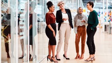 Four businesswomen standing together chatting