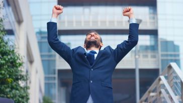 Businessman cheerin g with his arms in the air