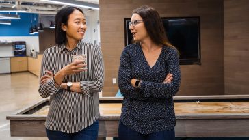 Two Alteryx team members chatting in the office