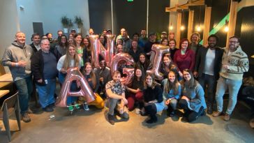 Angi group photo with team members holding ballons that spell ANGI