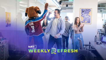 Bernie the St. Bernard high fives a monday.com employee at Monday.com's new Denver office.