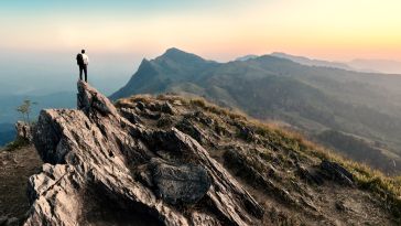 A photo depicting a person on a journey, climbing through a mountainous area.