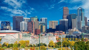 Downtown Denver during the day with Elitch Gardens in the foreground.