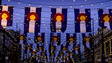nighttime photo of colorado flags with string lights