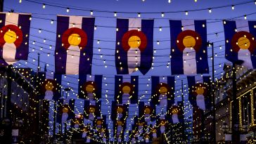 nighttime photo of colorado flags with string lights