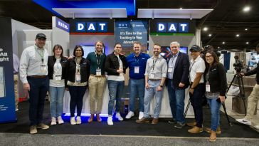 Photo of DAT team members in front of their booth at an expo.